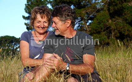 An older couple sitting in tall grass