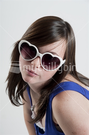 Teenage girl posing with heart sunglasses