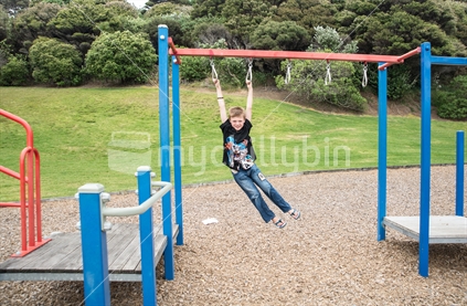 Boy playing on Playground equipment.