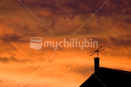 Roof silhouetted against a blazing orange sky