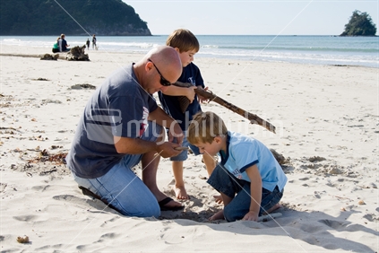 Dad with two boys playing at beach
