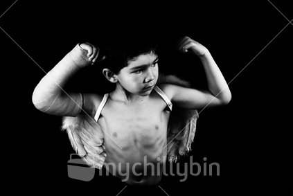 Boy with a broken arm flexes his muscles with Angel wings