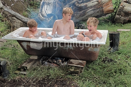 Three brothers having a spa bath outside on the farm