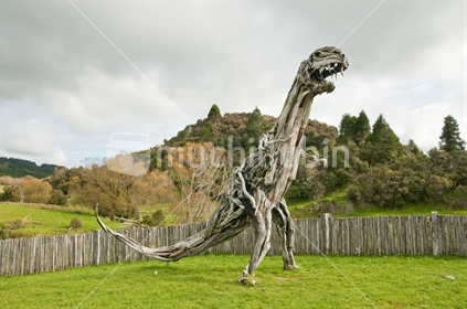 a replica dinosaur stands welcoming people to Raurimu