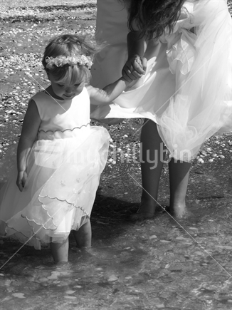 A flowergirl paddling with the bride