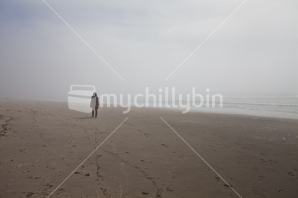 Walking into the mist on a New Zealand beach.
