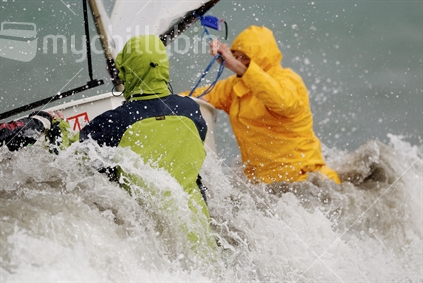 Sailors battling the elements as they launch their yacht.