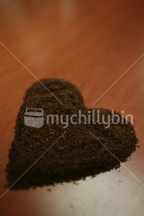 Ground coffee beans in the shape of a heart