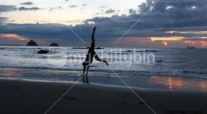 Hand stand on the beach