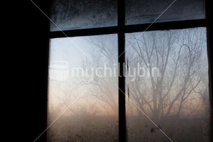 A New Zealand winter sunrise, through a window.