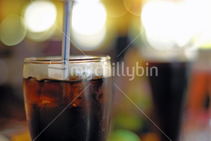 A glass of cola with a straw