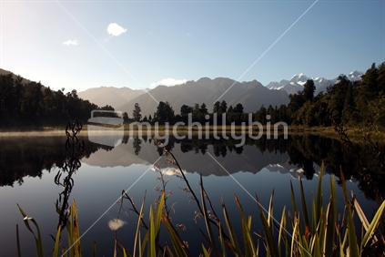 Southern Alps, reflecting in a calm Lake Matheson, South Island, New Zealand.