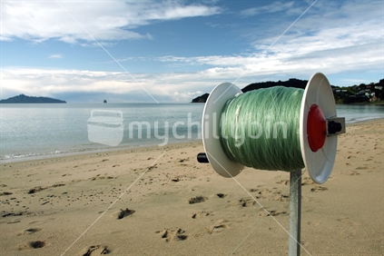 Reel with fishing line for kite or kontiki fishing on Lang's Beach, New Zealand.