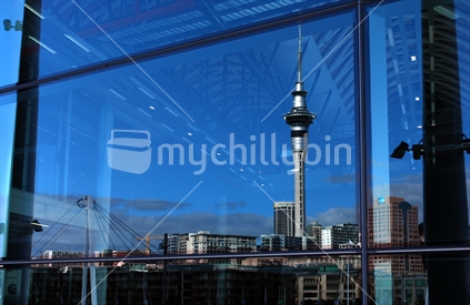 Auckland CBD reflected in the glass facade of Viaduct Events Centre.