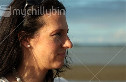 Portrait of young calm woman, outdoors on an Auckland beach