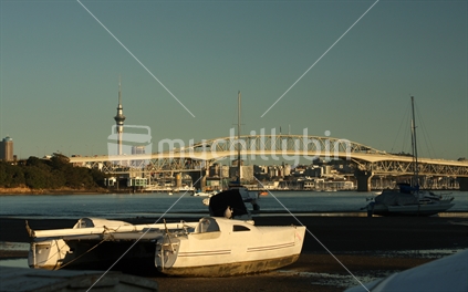Boat at Little Shoal Bay with AKL Harbour Bridge in the background