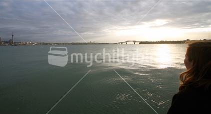 Auckland Skyline, Waitemata Harbour & Harbour Brige at sunset on a cloudy day
