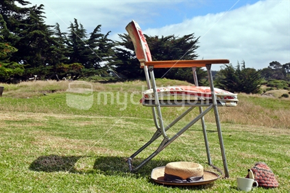 Retro sun chair with kiwiana teapot and cup outdoors