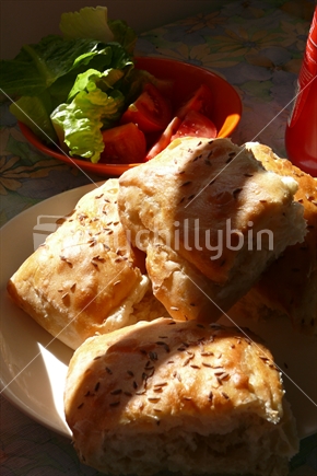 Fresh Turkish bread with cumin seeds and fresh salad in sunlight