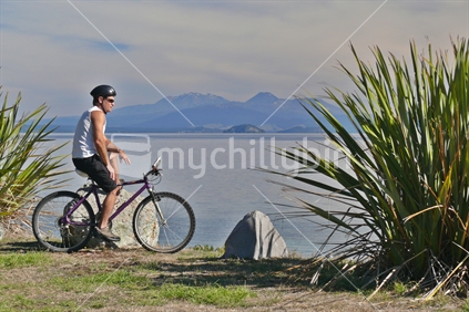 Man biking along the shores of Lake Taupo, North Island, New Zealand
