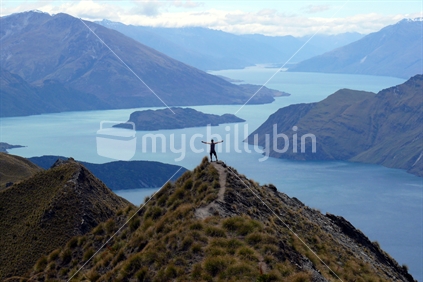 One person standing on the edge of the lower peak of the Roy Peak track, Wanaka