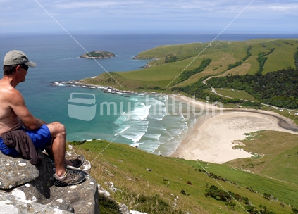 Man looking over Purakanui Beach, The Catlins, during a New Zealand summer