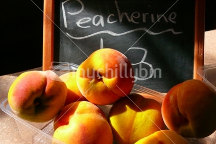 Peacherines, with blackboard sign ready for sale in New Zealand roadside fruit stall