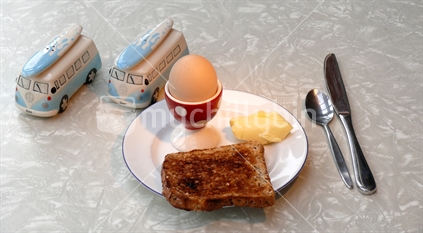 Egg, toast and butter; with retro combi van salt and pepper shakers, knife and spoon.