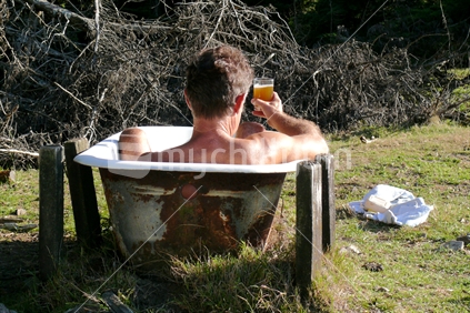 Man on holiday with beer, bach and bath.