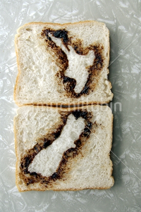 Slices of white bread with map of New Zealand stenciled on with yeast spread (Marmite or Vegemite).