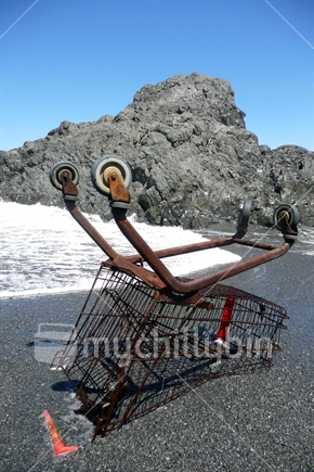 When shopping goes bad - upside down shopping trolley in surf.