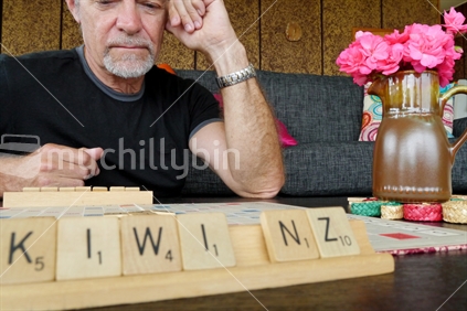 Man playing scrabble during quiet time during holiday