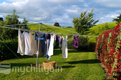 Old fashioned rotary clothesline (seen straighter days) with clothes drying in rural setting
