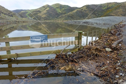 A flooded lake, Pencarrow, with vehicles to keep to formed road sign. 