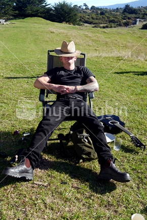 Young man with tattoo, resting in the sun.