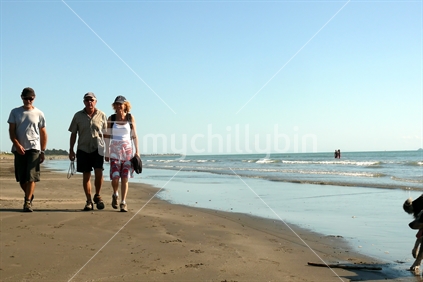 Older trio walking along beach