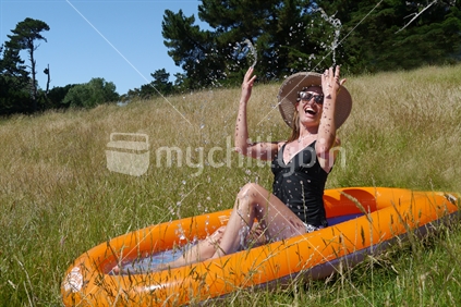 Quirky girl posing in a slip and slide pool