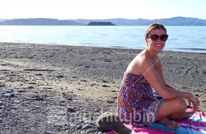 Young woman sitting on Eastbourne Beach, Wellington