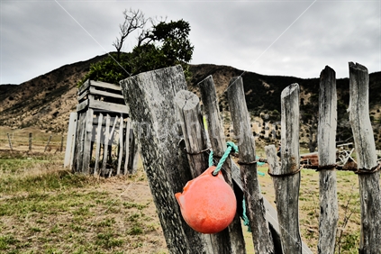 Buoy tied onto rustic fence post