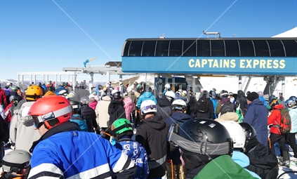 Skiers and snowboarders queuing at Captain's Basin chairlift, Cardrona Ski Field