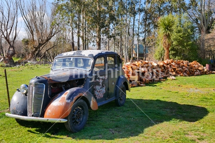 Vintage car with wood pile behind