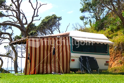 Caravan and awning perched on hill by ocean