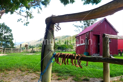 Implement shed with hitching rail and horseshoes in the foreground