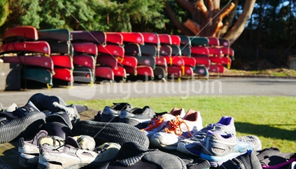Shoes drying out with canoes in background