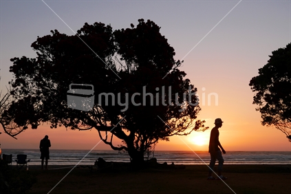 Two men silhouetted in sunset