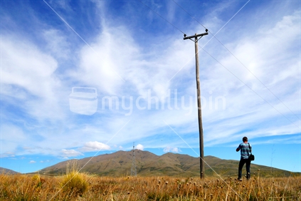 Power poles and man on the Hekataramea Valley Road, Canterbury