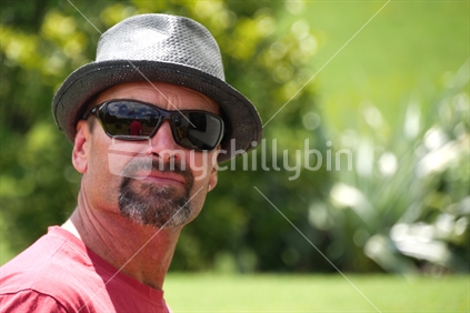 Middle aged man wearing sunglasses and sunhat in summer
