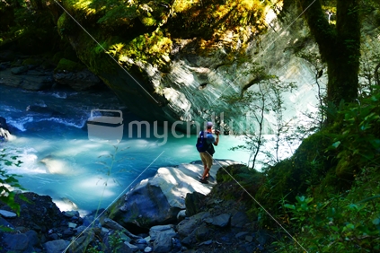Man standing by glacial river 