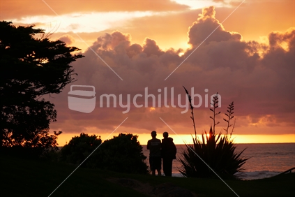 Couple watching the sun set in Taranaki