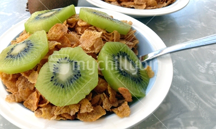 Bowl of cereal and kiwifruit on retro dining table
